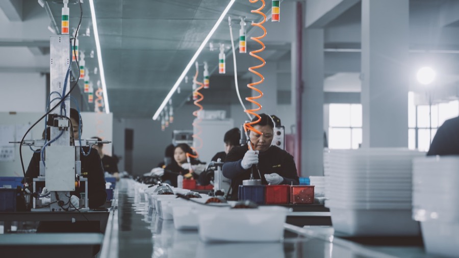 Workers along a production line inside a plant.