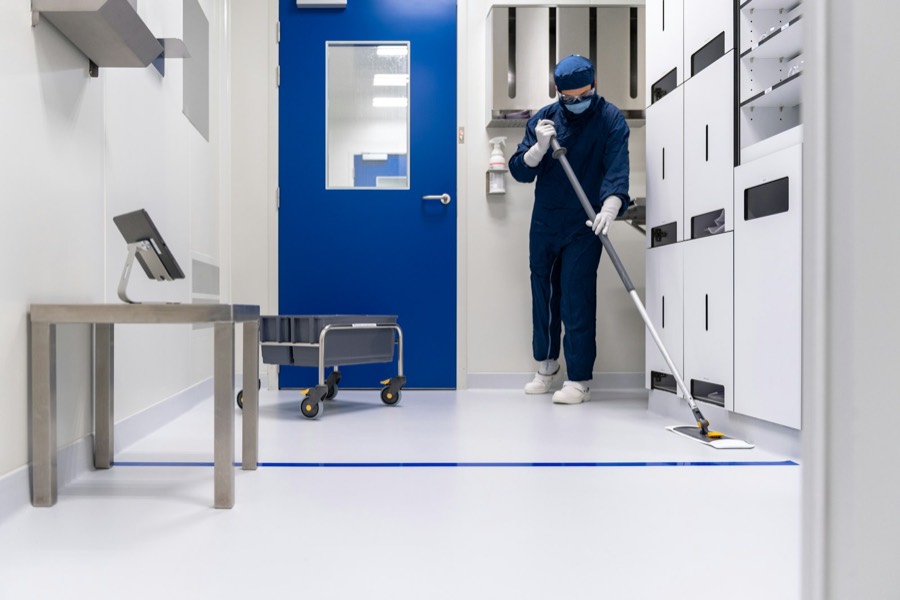 A cleaner working a controlled area corridor.