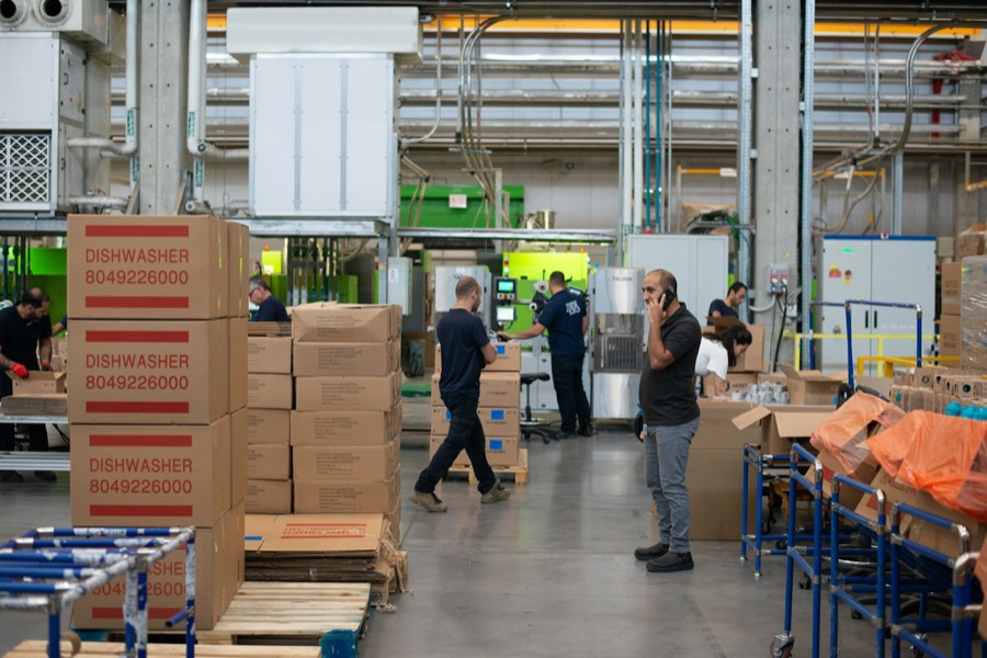 Crews moving cartons and pallets inside a warehouse.